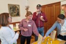 Mehrere Personen stehen um einen Tisch und riechen an Kräutern