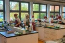 eine große Küche mit vielen Kochkojen und jeweils 2 Frauen, welche dort kochen