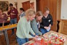Drei Frauen stehen vor einem Tisch und betrachten Kärtchen