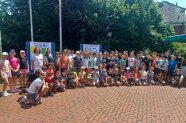 Erwachsene und Kinder stehen in einer Gruppe zusammen