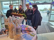Eine Gruppe junger Menschen stehen hinter einem Stehtisch