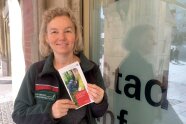Frau Hagen, Leiterin des Walderlebniszentrum Grünwald, hält einen Flyer hoch