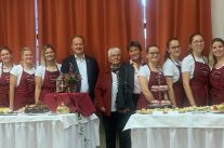 mehrere Frauen und ein Mann stehen hinter einem Buffet