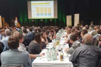 viele Personen schauen auf eine Leinwand