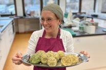 Eine Frau präsentiert ihre selbstgemachten Knödel