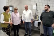 4 Personen stehen in einer Großküche und unterhalten sich 