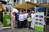 Frauen und Männer stehen in einer Gruppe mit Plakaten zusammen