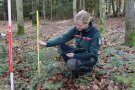 Eine Försterin misst einen Baum