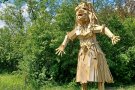 Eine Holzfrau steht auf einer Wiese