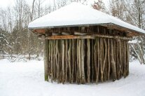 Klanglabyrinth im Winter mit Schnee bedeckt, im Hintergrund der Wald