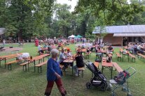 Menschenmenge essend und trinkend auf Bierbänken auf der Wiese beim WEZ